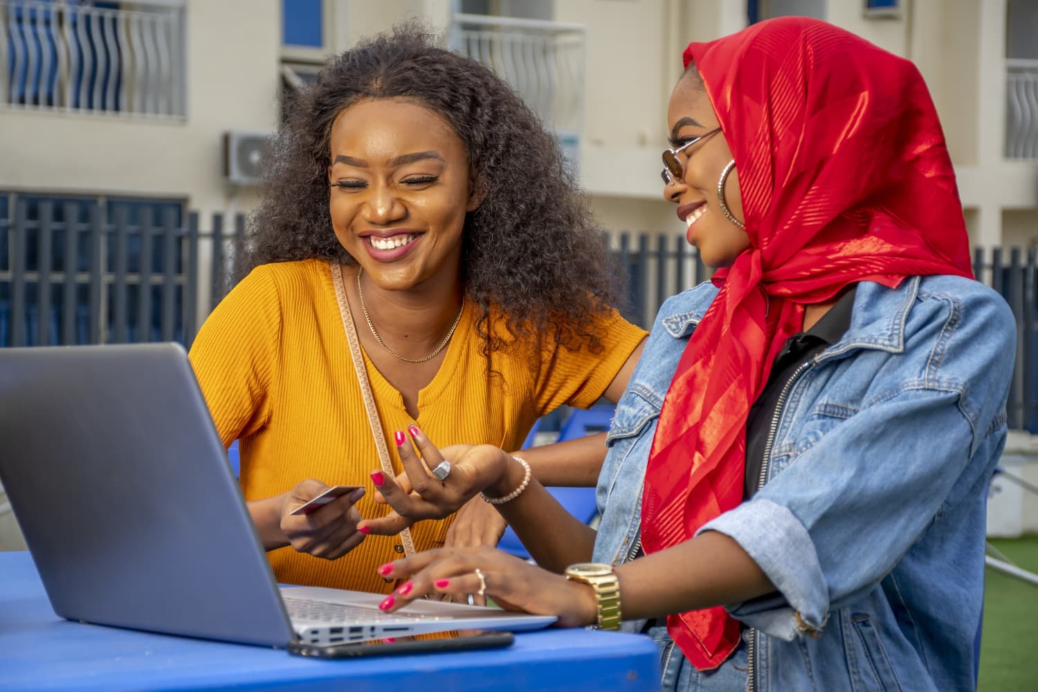 Two women shopping online together and smiling